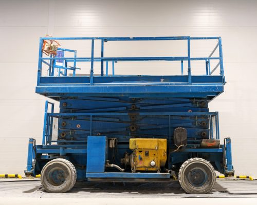 Hydraulic lifting platform on the construction site Hydraulic lifting platform on the construction site of an industrial building. A scissor elevator inside a warehouse