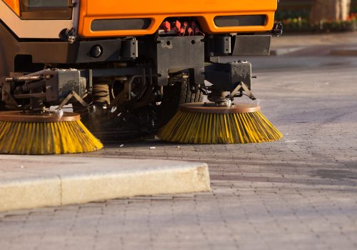 Street cleaner vehicle Yellow urban sweeper cleans road from dirt with a round brush
